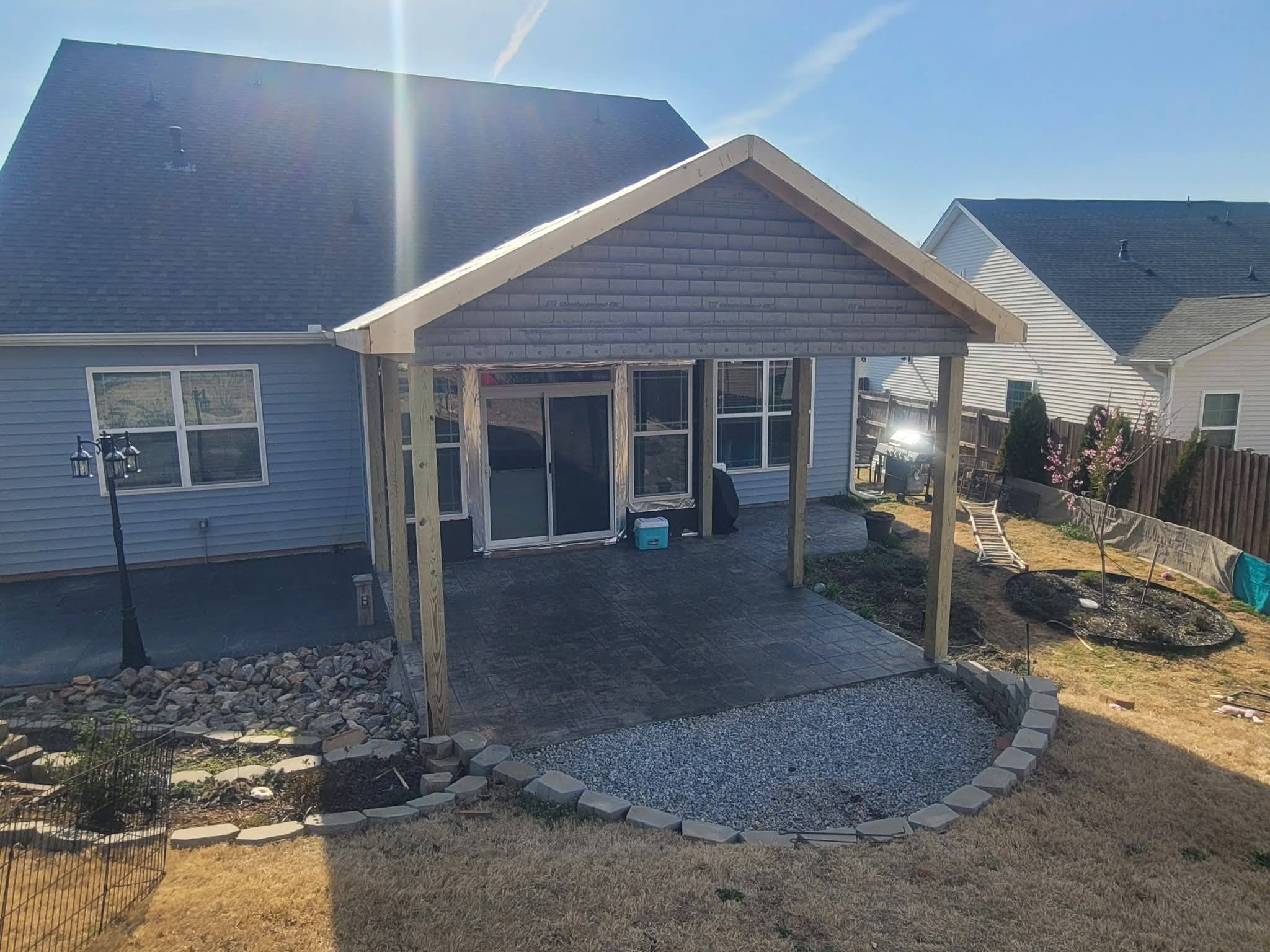 Gable-roof covered patio over stamped concrete